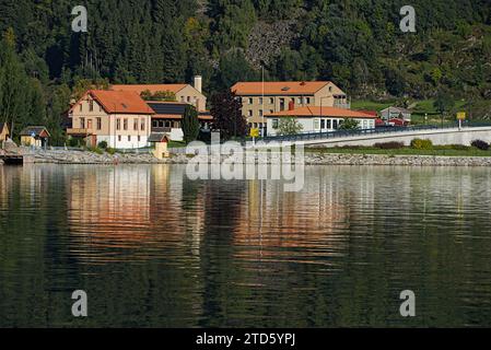 Edifici colorati lungo la collina e i loro riflessi sul lago a Sogndal, Norvegia. Foto Stock