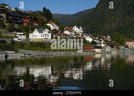 Edifici colorati lungo la collina e i loro riflessi sul lago a Sogndal, Norvegia. Foto Stock