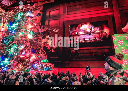 Londra, Regno Unito. 16 dicembre 2023. Un albero di Natale gigante e un fuoco di tronchi appaiono sugli schermi. L'Outernet, un luogo di intrattenimento gratuito e un'attrazione turistica coinvolgente con schermi LED avvolgenti vicino alla stazione di Tottenham Court Road nel West End di Londra, si riunisce una grande folla di appassionati di shopping, turisti e visitatori del West End. Crediti: Imageplotter/Alamy Live News Foto Stock