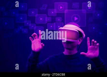 Uomo che indossa occhiali VR Virtual touch servizio di social networking e streaming di video e musica. Display touchscreen futuristico con immagini in streaming, co Foto Stock