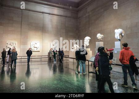 Londra, Regno Unito. 16 dicembre 2023. I turisti e i visitatori ammirano le sculture del frontone occidentale. Circa la metà dei marmi di Elgin, le antiche sculture greche del Partenone all'Acropoli di Atene, furono prese dalla Grecia dal conte di Elgin all'inizio del XIX secolo. Sono oggetto di una lunga controversia internazionale e la Grecia vorrebbe che le sculture venissero restituite. Di recente, il primo ministro britannico Rishi Sunak ha annullato gli incontri con il primo ministro greco Kyriakos Mitsotakis quando quest'ultimo ha sollevato l'argomento nei colloqui con la stampa. Crediti: Imageplotter/Alamy Live News Foto Stock