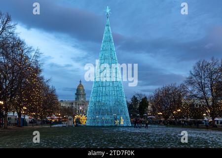 Denver, Colorado - 10 dicembre 2023: Abete artificiale con colorate decorazioni natalizie, strisce luminose a LED nel parco del Denver Civic Center Foto Stock