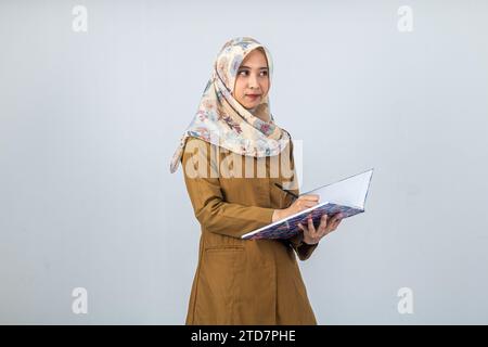 Giovane donna indonesiana dipendente del governo che indossa un'uniforme marrone. Foto Stock