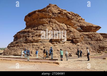 Turisti nel sito petroglifico della montagna Umm Sinman nel deserto arabo Foto Stock
