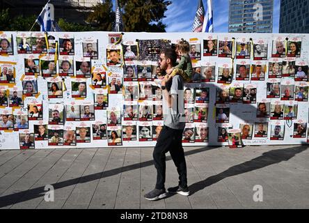 Tel Aviv, Israele. 16 dicembre 2023. La gente cammina davanti alle foto di ostaggi israeliani tenuti prigionieri da Hamas a Gaza in Piazza degli ostaggi fuori dal Museo di Tel Aviv a Tel Aviv, sabato 16 dicembre 2023. Le forze israeliane aprirono il fuoco, uccidendo tre ostaggi scambiati per Hamas. Foto di Debbie Hill/ Credit: UPI/Alamy Live News Foto Stock