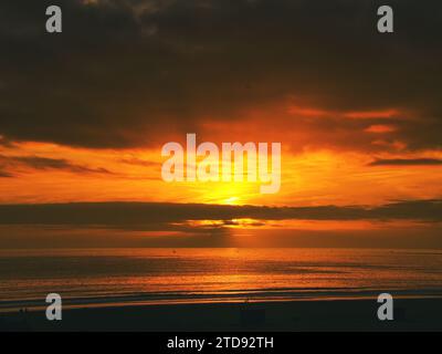 Tramonto dorato su una spiaggia tranquilla, con mari calmi che brillano nelle sfumature d'oro. Tranquillo paesaggio marino. Foto Stock