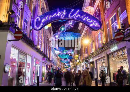 LONDRA, Regno Unito - 5 dicembre 2023: Decorazioni natalizie lungo Carnaby Street nel centro di Londra durante le festività. Le persone possono essere viste fuori. Foto Stock