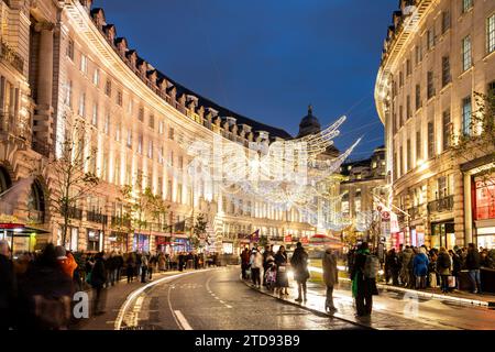 LONDRA, Regno Unito - 5 dicembre 2023: Decorazioni natalizie lungo Regent Street nel centro di Londra durante le festività. Persone e traffico possono essere visti Foto Stock