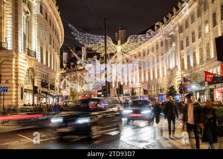 LONDRA, Regno Unito - 18 novembre 2023: Decorazioni natalizie lungo Regent Street nel centro di Londra durante le festività. Persone e traffico possono essere visti Foto Stock
