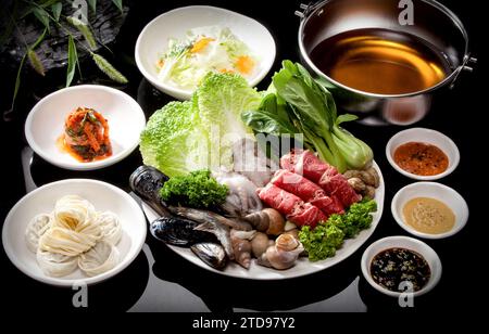 Ingredienti per cucinare shabu-shabu su sfondo nero Foto Stock