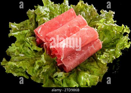 Tagliate a fette sottili ​​beef sopra la lattuga e arrotolate Foto Stock