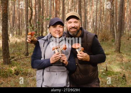 Due raccoglitori di funghi nella foresta tengono in mano gli alberi di aspen. Funghi nella foresta. Raccolta di funghi. Foto Stock