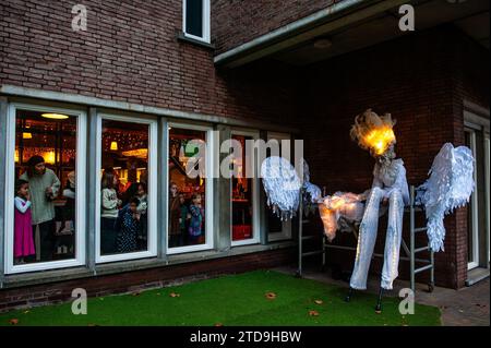 Nijmegen, Gelderland, Paesi Bassi. 16 dicembre 2023. Una donna si prepara sotto l'occhio vigile di un gruppo di bambini. La stagione natalizia è iniziata a Nijmegen con una bella sfilata invernale composta da un gruppo di artisti acrobatici che camminano su palafitte caratterizzate da creature fantasy. Una volta arrivato a Plein 1944, Erik van Zanten, presidente della "Casa per il centro città", e il consigliere John Brom aprirono le settimane invernali di Nijmegen con l'illuminazione di un albero di Natale alto dieci metri. (Immagine di credito: © Ana Fernandez/SOPA Images via ZUMA Press Wire) SOLO USO EDITORIALE! Non per USO commerciale! Foto Stock