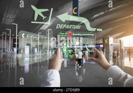 Una donna che riceve informazioni utilizzando apparecchiature AR in aeroporto (un ologramma viene visualizzato utilizzando una piastra acrilica trasparente) Foto Stock