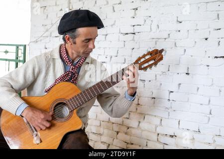 Argentina, San Antonio de Areco, El Ombu, Gaucho che suona la chitarra. Foto Stock
