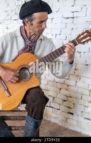 Argentina, San Antonio de Areco, El Ombu, Gaucho che suona la chitarra. Foto Stock