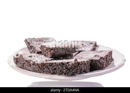 Alcuni pezzi di classico brownie al cioccolato su un piatto di ceramica, macro, isolato su sfondo bianco. Foto Stock