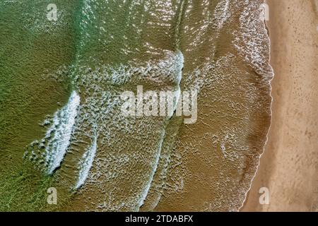 Una vista rilassante: Sopra la vista delle onde che si infrangono su una spiaggia Foto Stock