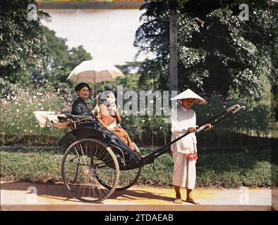 Hà-nôi, Hainoi Vietnam, Tonchino, Indocina due eleganti persone della classe superiore, in risciò in un giardino pubblico, esseri umani, abbigliamento, trasporto, alloggio, architettura, donna, Costume, trasporto a mano, Rickshaw, ritratto, Fiore, acconciatura, bretella di fissaggio, Park, giardino, uomo, Indocina, Tonchino, donne, classe superiore, due giovani eleganti in risciò, Hà-nôi, Hainoi Vietnam, 01/09/1915 - 30/11/1915, occupato, Léon, fotografo Léon Busy en Indochine, Autochrome, foto, vetro, Autochrome, foto, positivo, orizzontale, dimensioni 9 x 12 cm Foto Stock