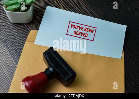 Il concetto di te è stato servito testo su documento sopra busta marrone isolato su tavolo di legno. Foto Stock