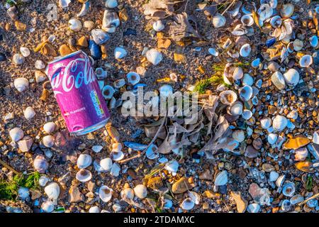 Una vecchia Coca-Cola sbiadita può essere lavata su una spiaggia di ciottoli. Foto Stock