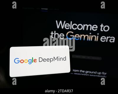 Persona che possiede uno smartphone con il logo della società di intelligenza artificiale Google DeepMind davanti al sito Web. Concentrarsi sul display del telefono. Foto Stock