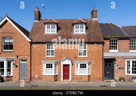 Tipica casa cittadina inglese in mattoni georgiani con un portico georgiano bianco di tipo aperto e una porta d'ingresso rossa. New Alresford, Inghilterra Foto Stock