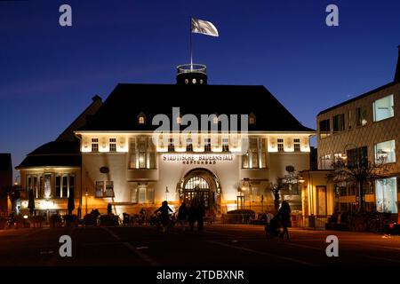 Colonia, Germania 17 dicembre 2023: Vista sulla neptunplatz di colonia Ehrenfeld fino allo storico neptunbad illuminato durante l'ora blu Foto Stock