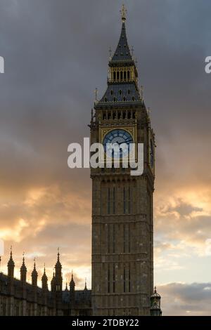 Elizabeth Tower retroilluminata con il Big Ben contro il cielo lungoso del tramonto Foto Stock