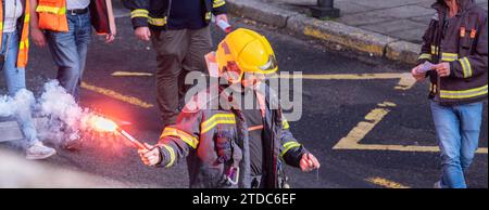 migliaia di firmeman protetti per le strade con i suoi uniforma, elmetti, striscioni e segnali di fuoco in strada Foto Stock