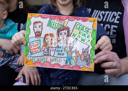 Seattle, Washington, USA. 17 dicembre 2023. La famiglia Harris-Klein posa con il loro disegno che sarà consegnato al senatore di Washington Patty Murray al Rainier Arts Center. Jewish Voice for Peace ha organizzato l'evento Portraits for Palestine a sostegno di un cessate il fuoco a Gaza. Credito: Paul Christian Gordon/Alamy Live News Foto Stock