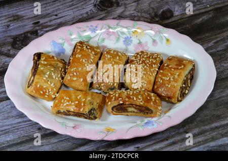 Pasta farcita con datteri e condita con semi di sesamo o Ka'ab El Ghazal, datteri egiziani o biscotti ripieni di Agwa Ajwa, famosa fille di datteri mediorientali Foto Stock