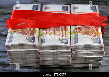 Pile e pile d'Egitto denaro migliaia di sterline banconote banconote da 200 EGP LE avvolte con nastro rosso, tasso di cambio egiziano e. Foto Stock