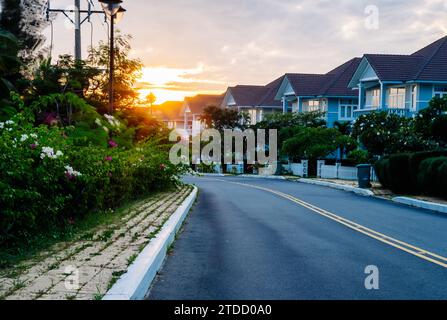 Moderni cottage fila strada marciapiede edifici a due piani ville residenziali villaggio nuovo Estate Reflection Dawn sole nelle finestre Foto Stock