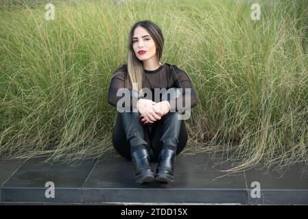 Bella giovane donna seduti all'aperto Foto Stock