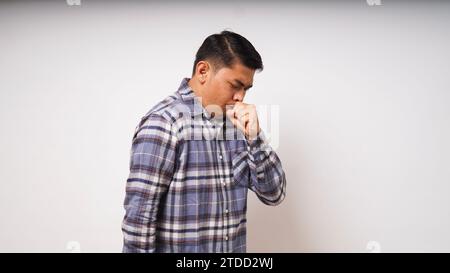 Giovane asiatico uomo fare tosse gesto su sfondo bianco. foto studio Foto Stock