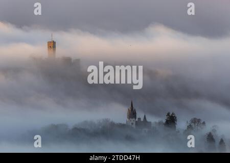 Königsteiner Burgen im Nebel die Burgruine Königstein sowie die Villa Andreae Schneider-Villa ragen am Morgen aus einer Nebeldecke., Königstein Hessen Deutschland *** Königstein castelli nella nebbia le rovine del castello di Königstein e della villa Andreae Schneider sorgono da una coperta di nebbia al mattino , Königstein Hessen Germania Foto Stock