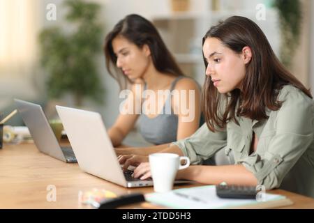 Due tele worker seri che lavorano online a casa Foto Stock