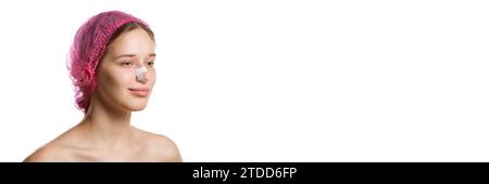 Banner. Ritratto di una donna attraente in berretto rosa con intonaci sul naso dopo rinoplastica su sfondo bianco dello studio con spazio per la copia. Foto Stock