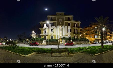 Panorama notturno di Piazza Anco Marzio situato nella zona pedonale e nel centro della vita notturna di Ostia Lido, un quartiere fronte mare di Roma. Foto Stock