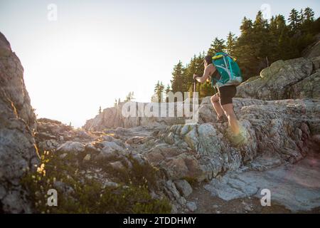 Vista laterale di FIT femmina che fa trekking su talus rock Foto Stock