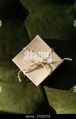 Piccola confezione regalo kraft legata con cordoncino con sfondo scuro Foto Stock