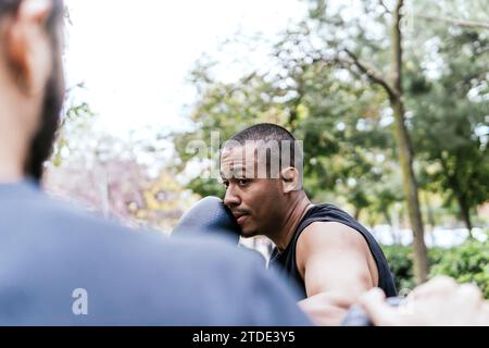 un uomo che pratica il wrestling proteggendo la sua faccia Foto Stock