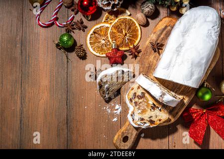 Tradizionale dressner stollencake di Natale con frutta secca, spezie, albero di Natale e decorazione su sfondo rustico in legno Foto Stock