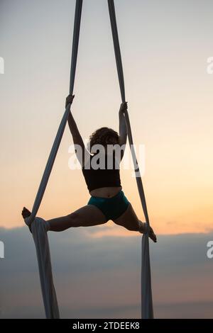 Giovane donna che si esibisce all'aria aperta con la seta Foto Stock