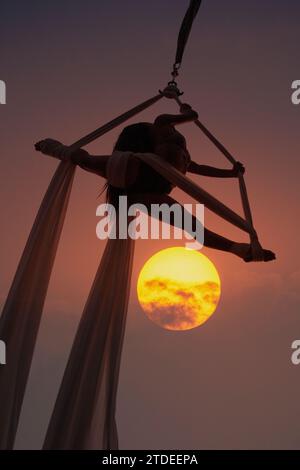 Giovane donna che si esibisce all'aria aperta con la seta Foto Stock