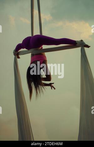 Giovane donna che si esibisce all'aria aperta con la seta Foto Stock