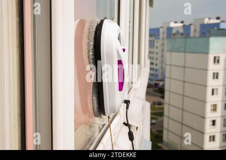Un moderno robot aspirapolvere lavavetri lavavetri in un appartamento su un balcone. Vista dall'esterno dalla strada. Sicurezza dalle cadute dall'alto, automati Foto Stock