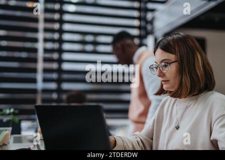 Team aziendali diversificati per l'espansione globale e la crescita dei ricavi in un ufficio moderno, collaborando per il successo e la sostenibilità. Foto Stock