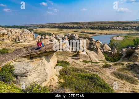 Bambini che giocano su un Hoodoo lungo il fiume Milk, Writing-on-Stone Provincial Park, sito patrimonio dell'umanità dell'UNESCO, Alberta, Canada, Nord America Foto Stock